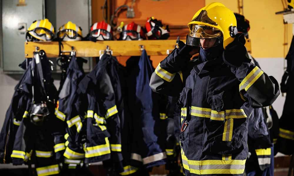 Fireman putting on turnout gear in fire station