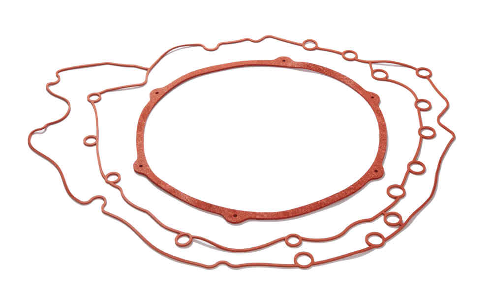Two red roughly circular large gaskets with bolt holes long outer edges