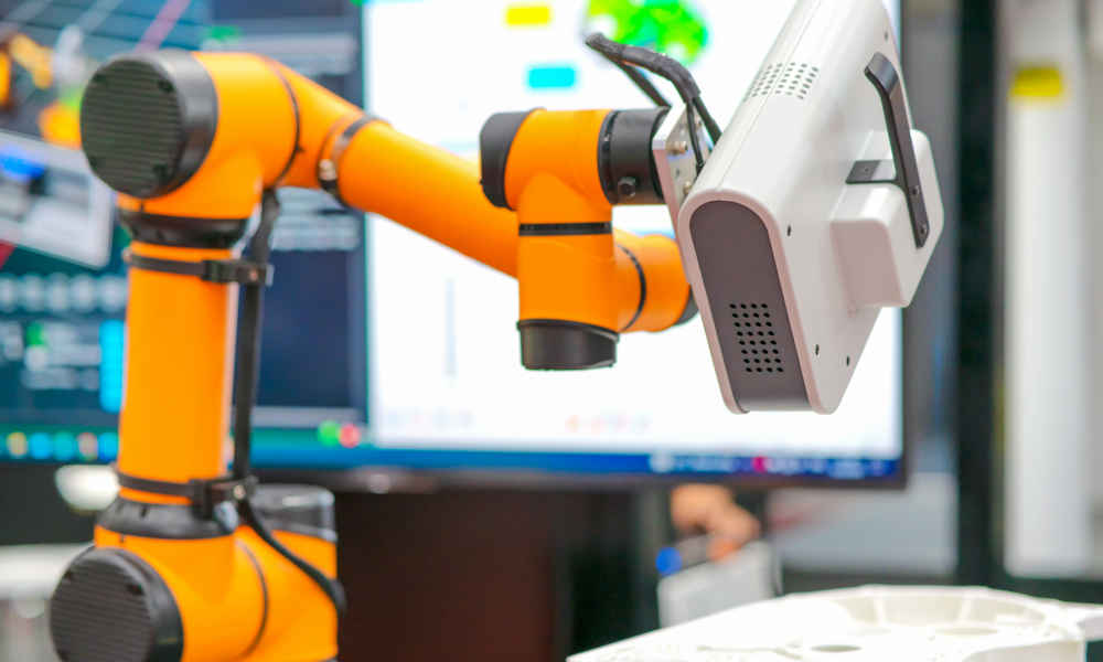 Orange robotic arm shown scanning an object