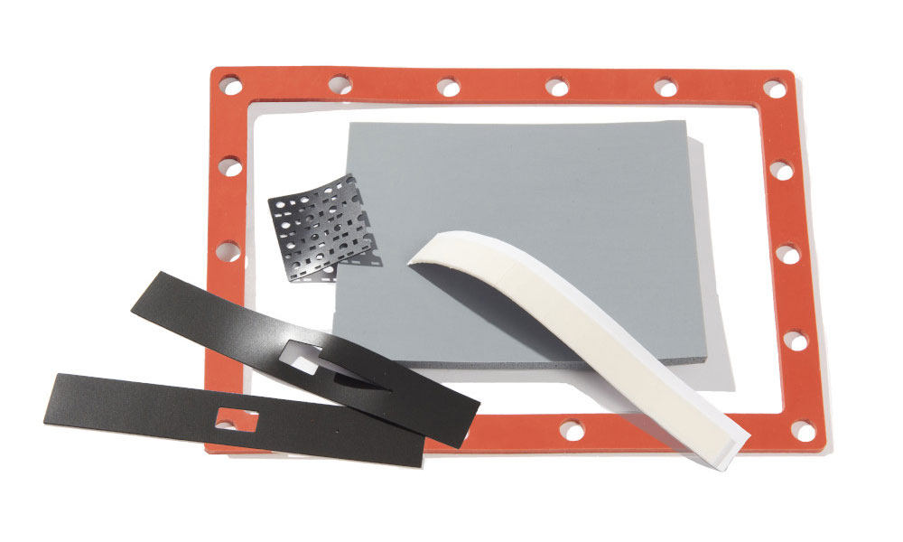 Red silicone gasket with two black Poron pads with cutouts and white kiss cut silicone foam